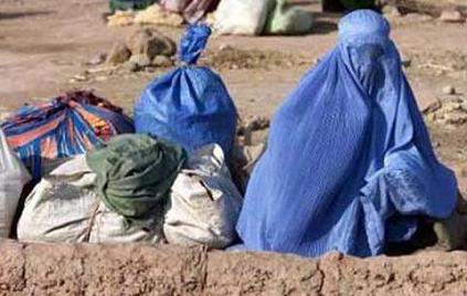 muslim woman in burqa next to garbage