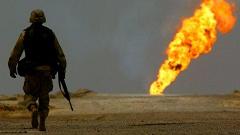 A US soldier walks towards a burning oil well in Iraq's vast Rumaila oil fields in this March 2003 photo: Even directly after the invasion, the US troops didn't pay close attention to the issue of oil.