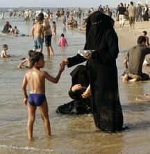 A Muslim woman at the beach with her son., Hatem Moussa / AP Photo