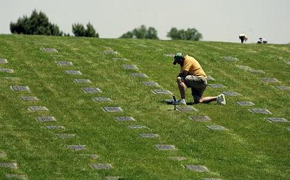 David Humphreys, of Trenton, N.J., kneels at the grave site of his Vietnam veteran father, David Humphreys, at Brigadier General William C. Doyle Veterans Memorial Cemetery Thursday, May 21, 2009, in Wrightstown, N.J. 