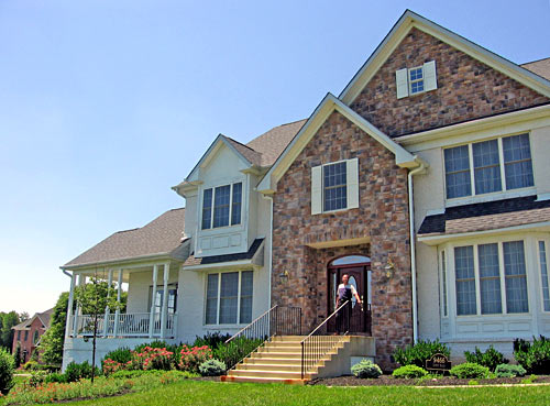 Michael Frisby stands outside the door to his 11,000-square-foot home in Fulton, Md.