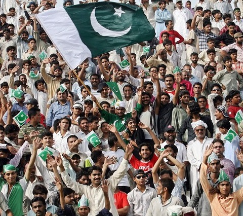 Pakistani people wave national flags