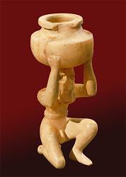 A kneeling, nude male figure holding a vessel is made of alabaster and was found at Shara Temple at Tell Agrab (ca. 2600 B.C.).