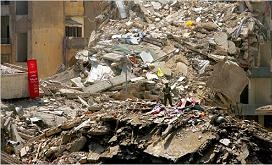 A man stood Wednesday on the site of a building in a southern suburb of Beirut destroyed by an Israeli attack. A sign, left, blamed the United States. 