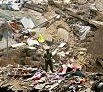 A man stood Wednesday on the site of a building in a southern suburb of Beirut destroyed by an Israeli attack. A sign, left, blamed the United States. 