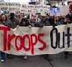 About 10,000 Bay Area residents brave the cold drizzle marching down Market Street in downtown San Francisco to express their opposition to Bush's Troop Surge.