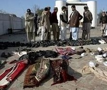 Pakistani security officials and local residents look at belongings of the victims at the site of suicide bombing in Sherpao, a village 40 kilometers northeast Peshawar, Pakistan on Friday, Dec. 21, 2007.