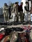Pakistani security officials and local residents look at belongings of the victims at the site of suicide bombing in Sherpao
