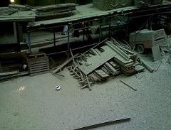 fallen worker behind scaffolding.  apparently the bucket dropped cement from the top causing floors to collapse and 2 workers to fall, 1 being caught in the safety net.