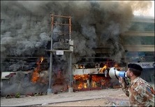 A Pakistani soldier shouts instructions to people trapped inside the burning Pizza Hut restaurant in Karachi.