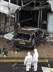 A police forensic team photographs the scene of Saturday's attack on the main terminal building at Glasgow Airport. The Jeep and gas canisters it carried were later taken away for further examination. Image © BBC