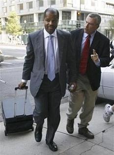 Administrative law judge Roy Pearson, left, is questioned by a member of the media as he leaves court after the second day of his lawsuit in Washington in this Wednesday, June 13, 2007 file photo. 